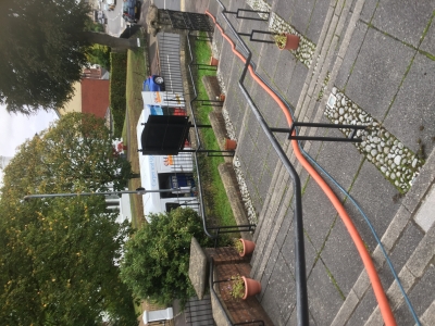 The van on the street with hoses leading to the foyer 